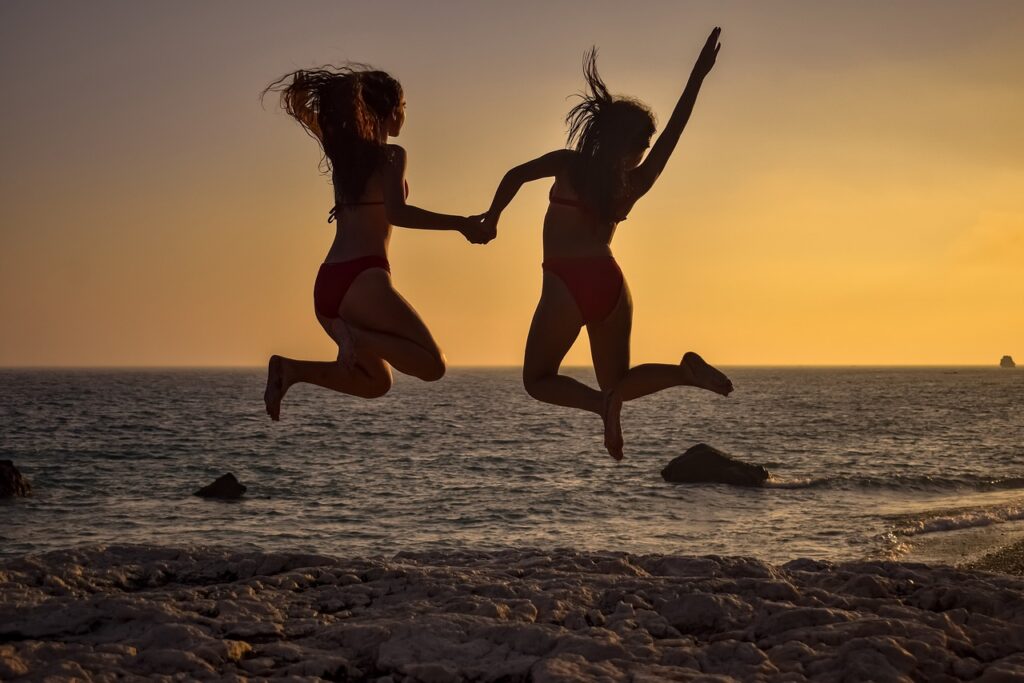 girls jumping beach